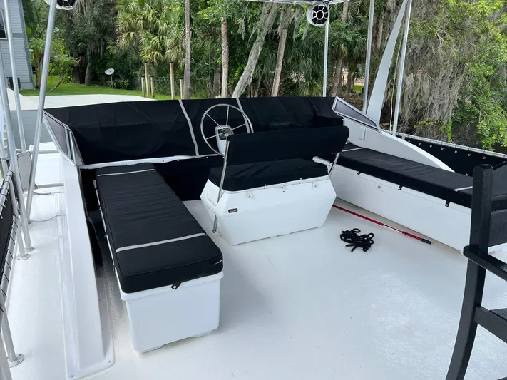 Slippery When Wet Yacht Photos Pics 1989 Sumerset Houseboat 64' x 14' with black seating and steering wheel on deck.