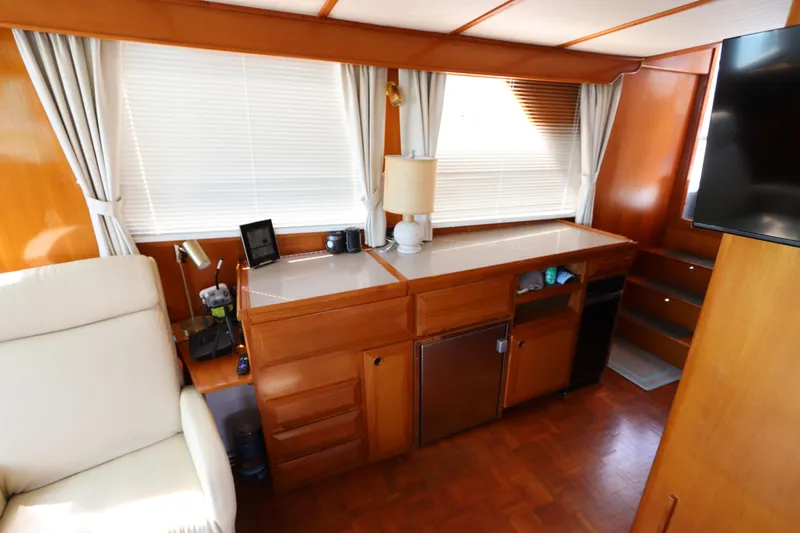 Sea Cow Yacht Photos Pics Interior of 2005 DeFever 49 Cockpit Motor Yacht with wooden cabinetry and seating area.