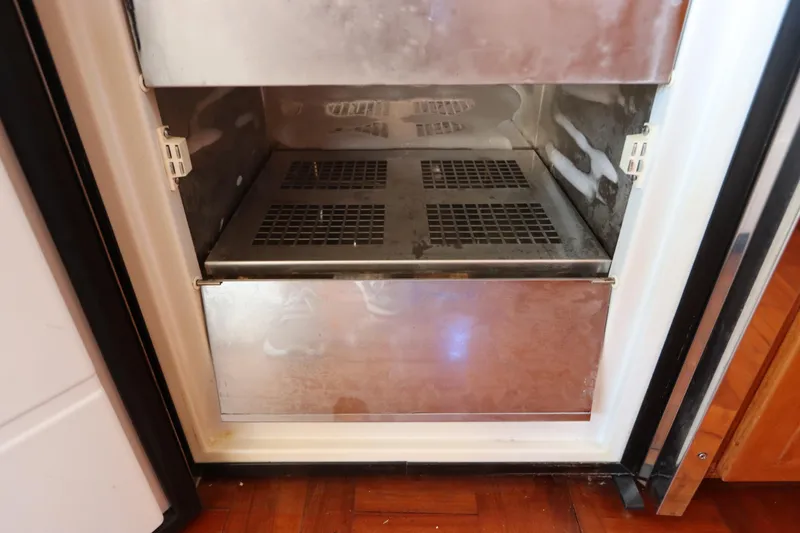 Sea Cow Yacht Photos Pics Open freezer compartment on 2005 DeFever 49 Cockpit Motor Yacht, showing interior details.