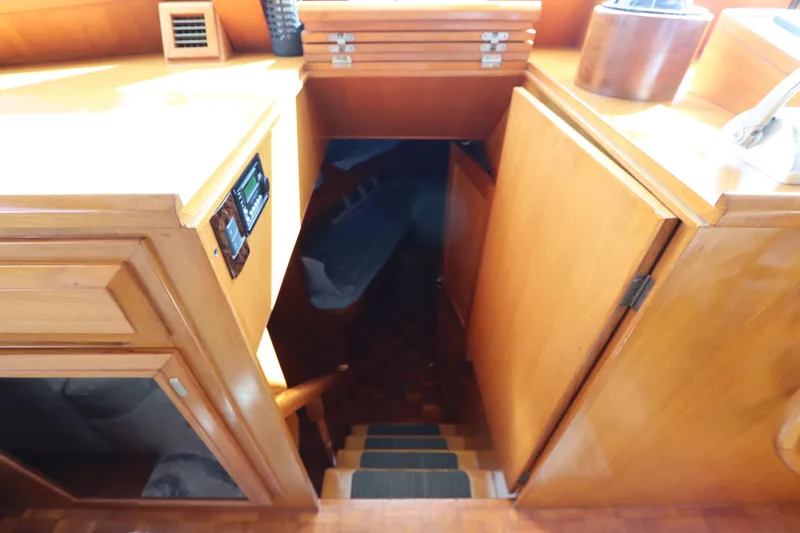 Sea Cow Yacht Photos Pics Interior view of 2005 DeFever 49 Cockpit Motor Yacht, featuring wooden cabinetry and stairs.