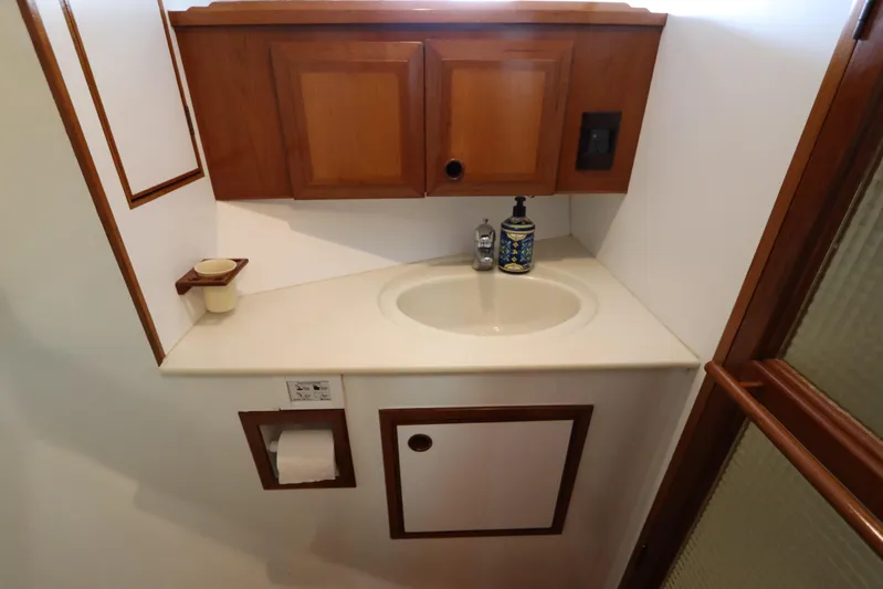 Sea Cow Yacht Photos Pics Bathroom sink area in a 2005 DeFever 49 Cockpit Motor Yacht with wooden cabinetry.