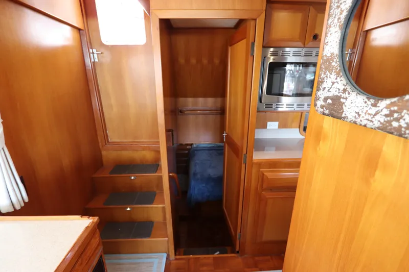 Sea Cow Yacht Photos Pics 2005 DeFever 49 Cockpit Motor Yacht interior with wooden cabinetry and compact kitchen.