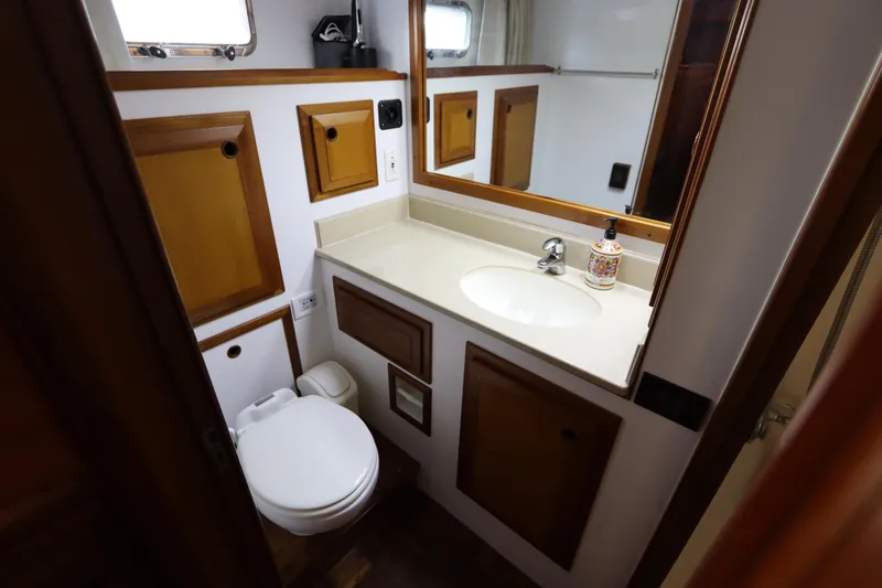 Sea Cow Yacht Photos Pics Bathroom interior of 2005 DeFever 49 Cockpit Motor Yacht with wooden cabinets and sink.