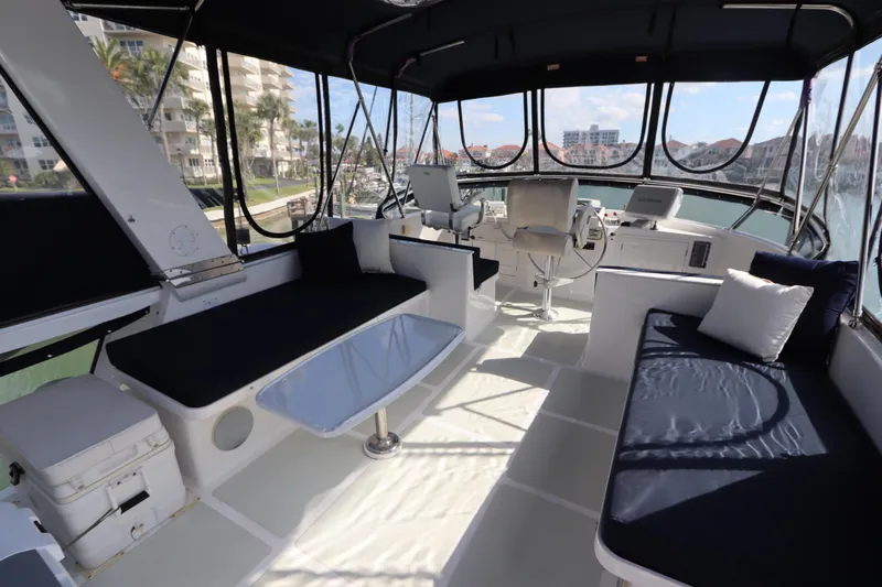 Sea Cow Yacht Photos Pics 2005 DeFever 49 Cockpit Motor Yacht interior with seating and helm, docked in marina.