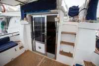 2005 Nimbus 380 Commander yacht deck with wooden flooring and sliding glass door.
