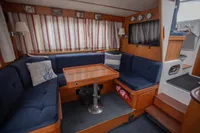 Cozy interior of 2005 Nimbus 380 Commander with blue seating and wooden table.