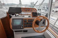 Control panel of 2005 Nimbus 380 Commander boat with steering wheel and navigation equipment.