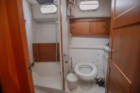 Bathroom interior of 2005 Nimbus 380 Commander yacht, featuring wooden cabinetry and compact design.
