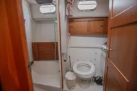 Compact bathroom in 2005 Nimbus 380 Commander yacht with wooden accents and porthole windows.