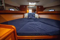 Cozy cabin interior of 2005 Nimbus 380 Commander with blue bedding and wooden accents.