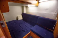 Cozy cabin interior of 2005 Nimbus 380 Commander with blue seating and wooden accents.