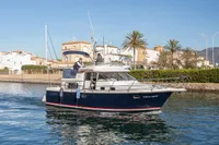 Nimbus 380 Commander 2005 yacht cruising near coastal homes and palm trees.