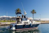 Nimbus 380 Commander 2005 yacht cruising near palm trees and mountains.