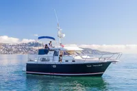 Nimbus 380 Commander 2005 yacht cruising on calm waters with scenic coastal backdrop.
