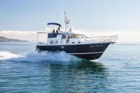 2005 Nimbus 380 Commander cruising on calm blue waters under clear skies.