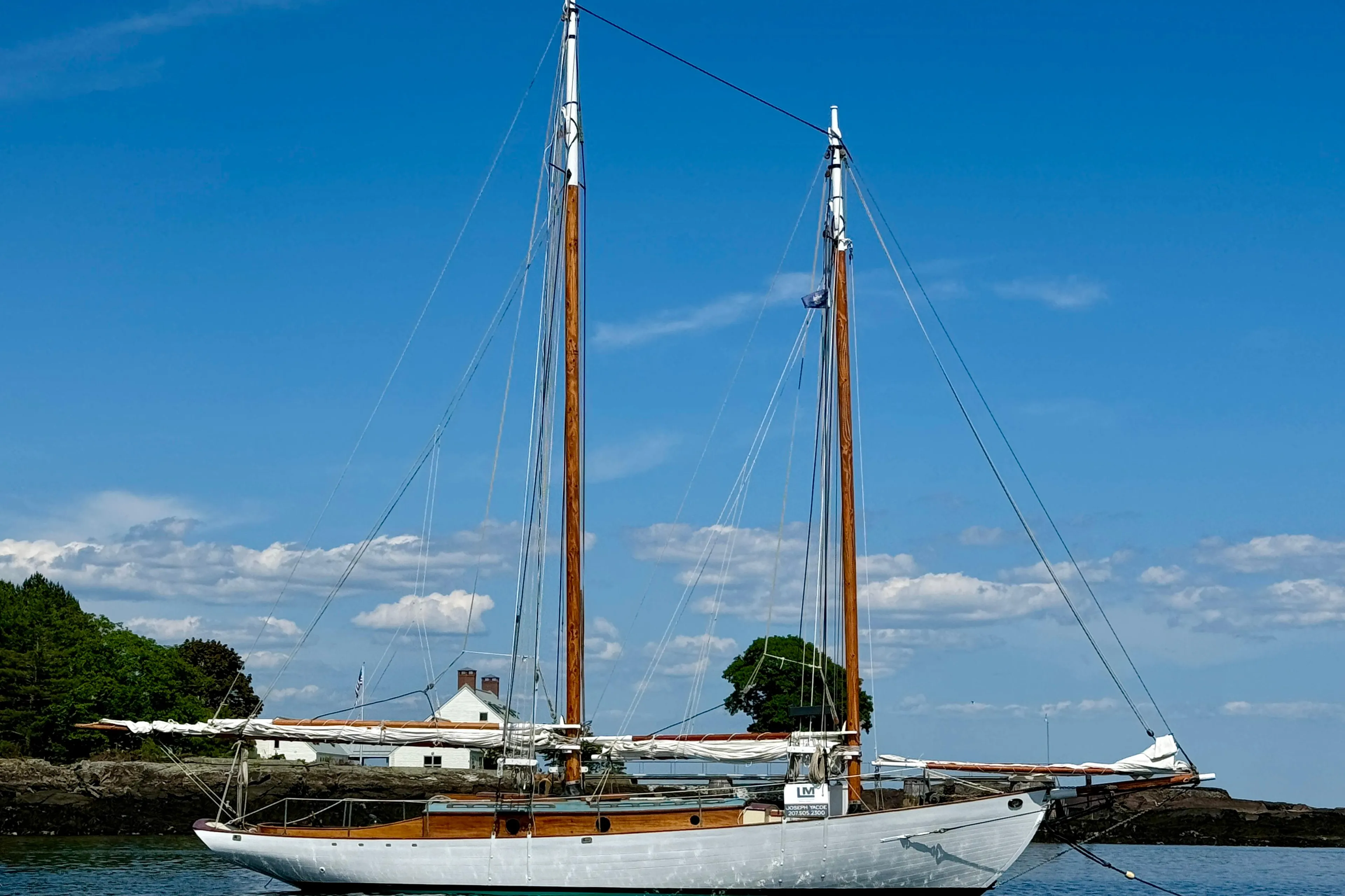 Sailing yacht "John Alden Malabar II" on calm waters, clear blue sky, 1996 model.