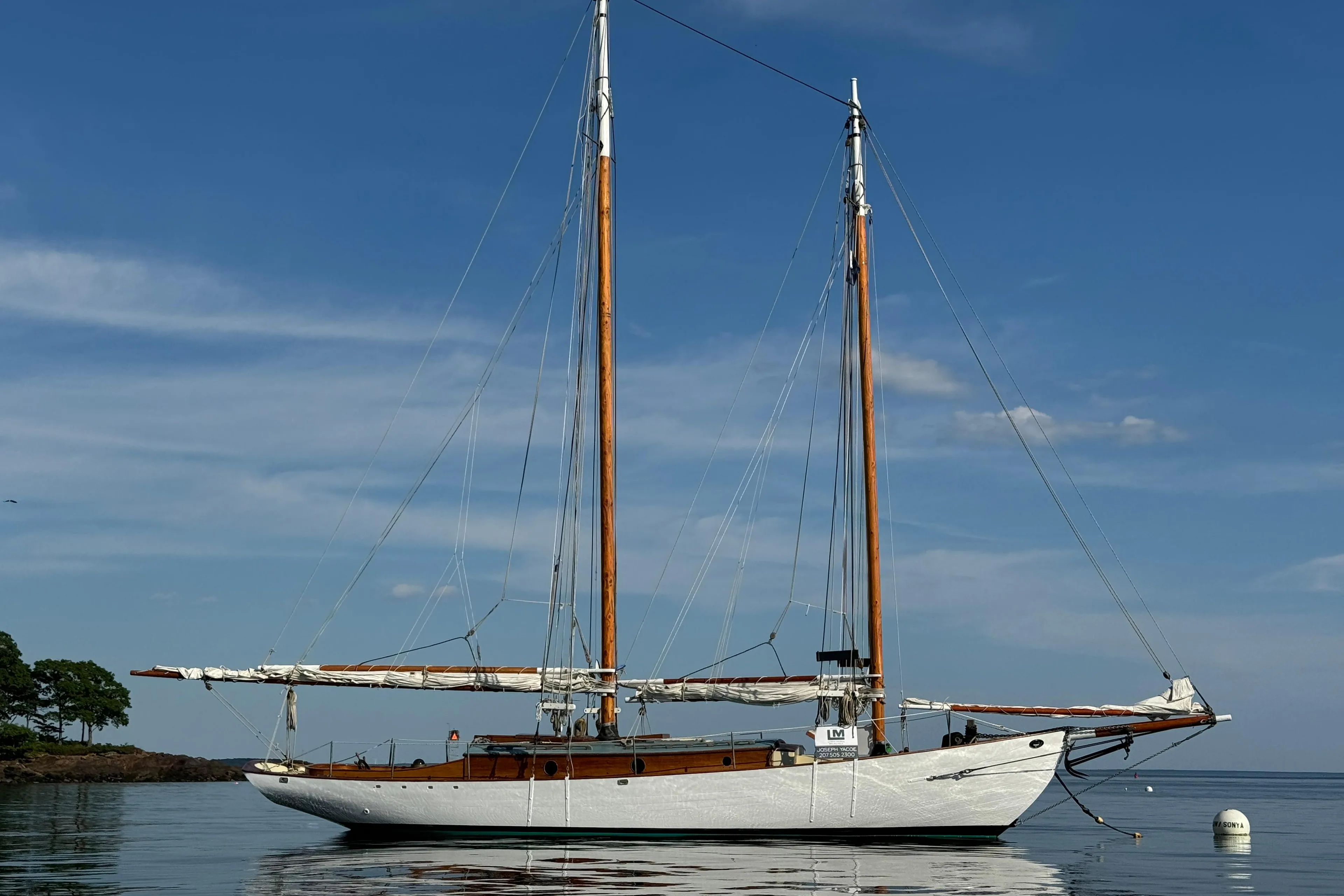 Sailing yacht "John Alden Malabar II" on calm water, 1996 model, clear sky background.