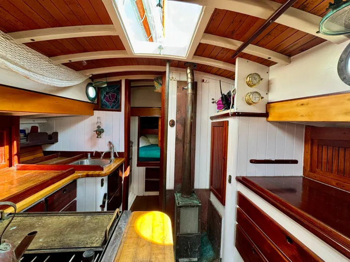 Alyria Yacht Photos Pics Interior of 1996 Custom John Alden Malabar II sailboat with wooden cabinetry and cozy design.