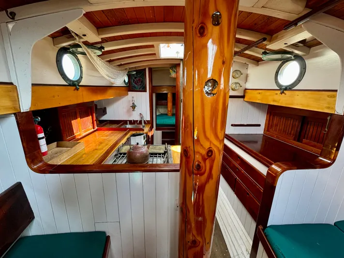 Alyria Yacht Photos Pics Interior of 1996 Custom John Alden Malabar II sailboat with wooden finishes and portholes.