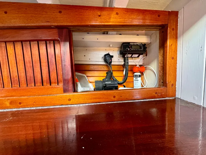 Alyria Yacht Photos Pics Wooden interior of a 1996 Custom John Alden Malabar II boat with communication equipment.