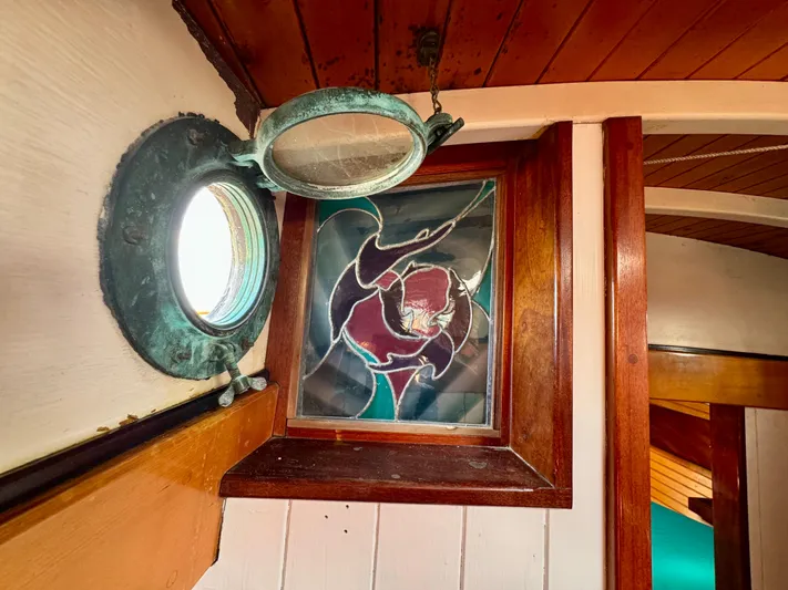 Alyria Yacht Photos Pics Stained glass window and porthole on 1996 Custom John Alden Malabar II boat interior.