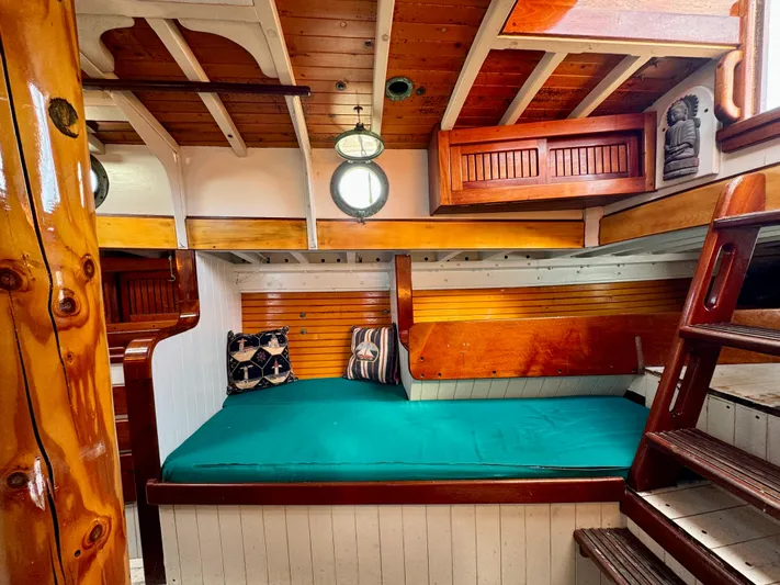Alyria Yacht Photos Pics Cozy cabin interior of 1996 Custom John Alden Malabar II with wooden accents and teal bedding.