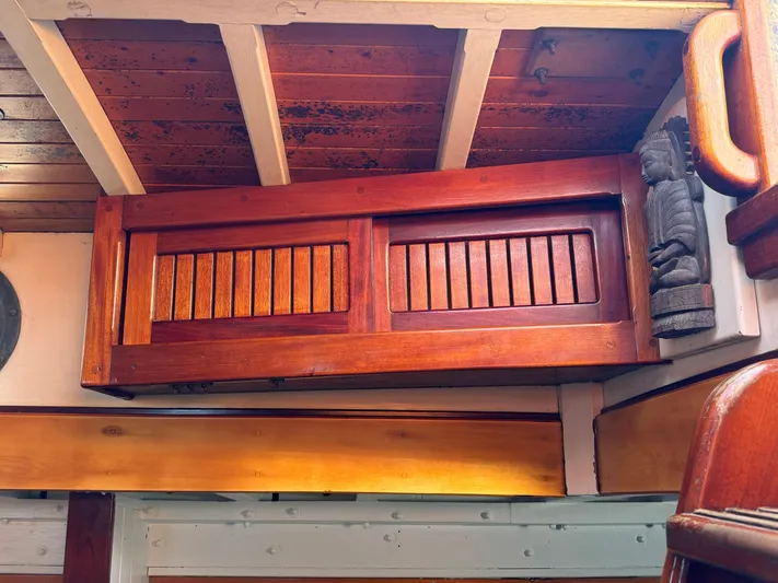 Alyria Yacht Photos Pics Wooden interior of 1996 Custom John Alden Malabar II boat, featuring detailed cabinetry and carvings.