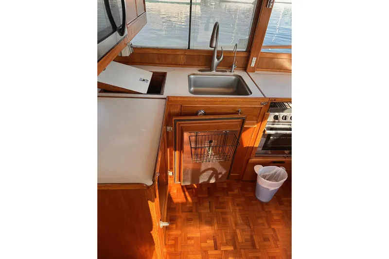 Tiger Moth (reserved) Yacht Photos Pics 1984 Grand Banks 42 Classic yacht kitchen with wooden cabinetry and stainless steel sink.