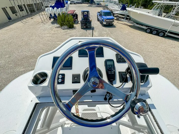  Yacht Photos Pics 2024 Caymas 28 HB boat helm with steering wheel and controls in a marina setting.