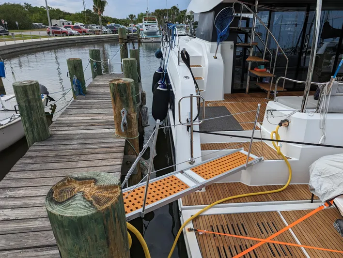 A New Hope Yacht Photos Pics Fountaine Pajot MY 44 yacht docked at marina, 2018 model, with wooden deck and gangway.
