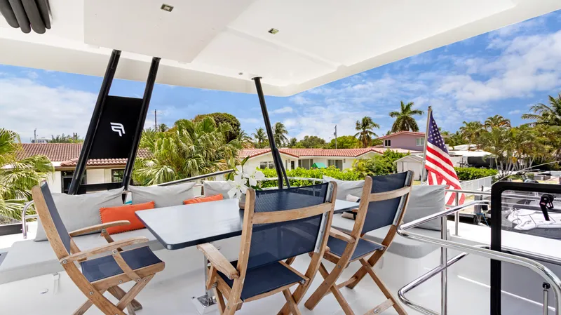 A New Hope Yacht Photos Pics 2018 Fountaine Pajot MY 44 yacht deck with dining area, chairs, and American flag.