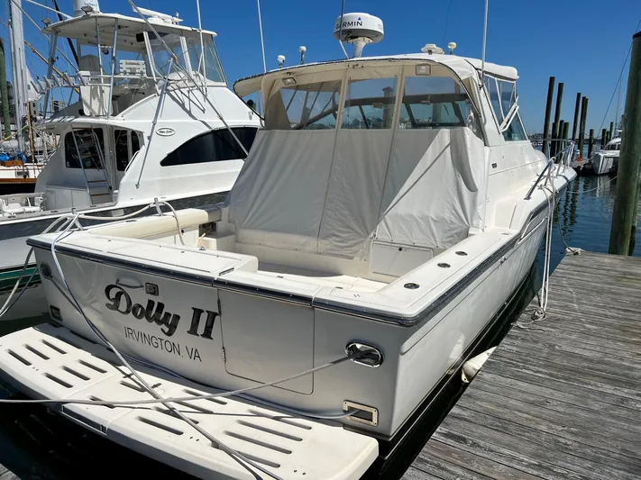 Chaos Yacht Photos Pics 1996 Tiara Yachts 4300 Open docked, featuring covered seating and sleek design.