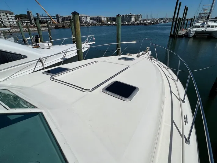 Chaos Yacht Photos Pics 1996 Tiara Yachts 4300 Open docked at marina, showcasing sleek deck design.