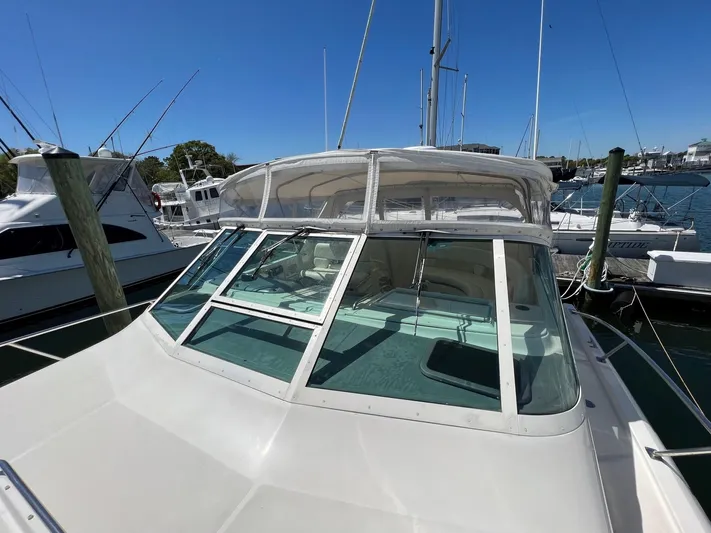 Chaos Yacht Photos Pics 1996 Tiara Yachts 4300 Open docked at marina under clear blue sky.