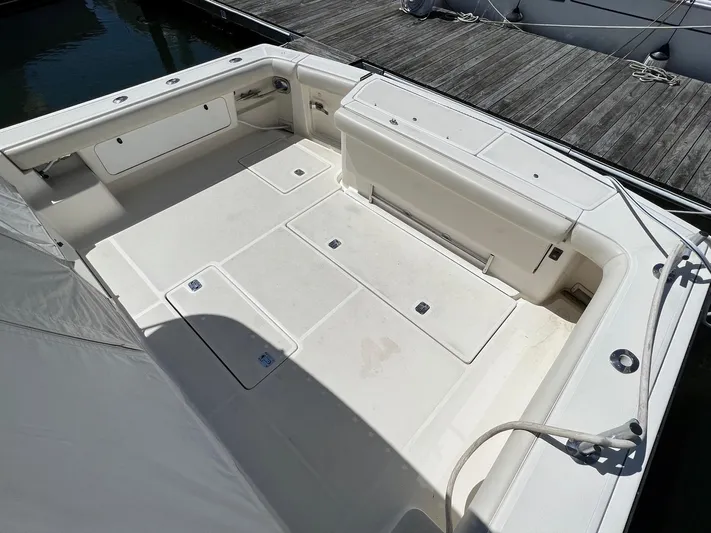 Chaos Yacht Photos Pics Spacious deck of 1996 Tiara Yachts 4300 Open, featuring clean white seating and storage.