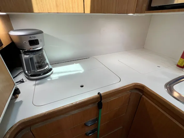 Chaos Yacht Photos Pics 1996 Tiara Yachts 4300 Open kitchen with coffee maker and wooden cabinetry.