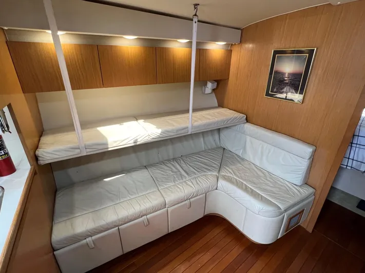 Chaos Yacht Photos Pics 1996 Tiara Yachts 4300 Open interior with white leather seating and wood paneling.