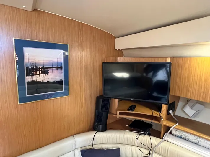Chaos Yacht Photos Pics Interior of 1996 Tiara Yachts 4300 Open with TV and framed nautical artwork.