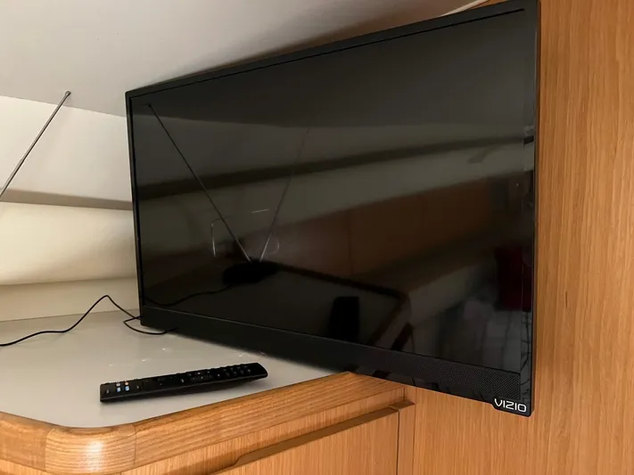 Chaos Yacht Photos Pics Flat-screen Vizio TV with remote on wooden cabinet inside 1996 Tiara Yachts 4300 Open.