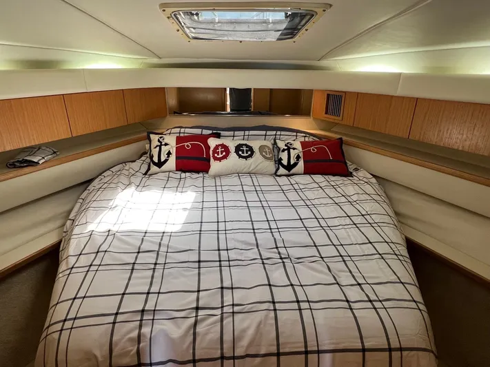 Chaos Yacht Photos Pics 1996 Tiara Yachts 4300 Open cabin with nautical-themed bedding and overhead skylight.