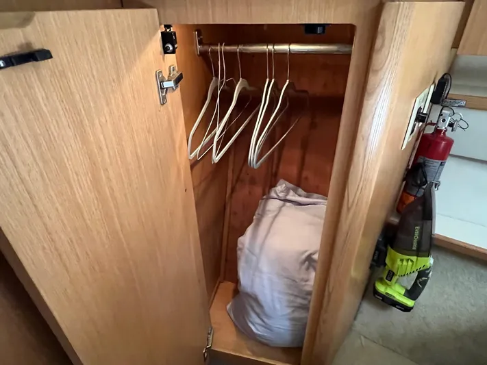 Chaos Yacht Photos Pics 1996 Tiara Yachts 4300 Open closet with hangers, vacuum, and fire extinguisher.
