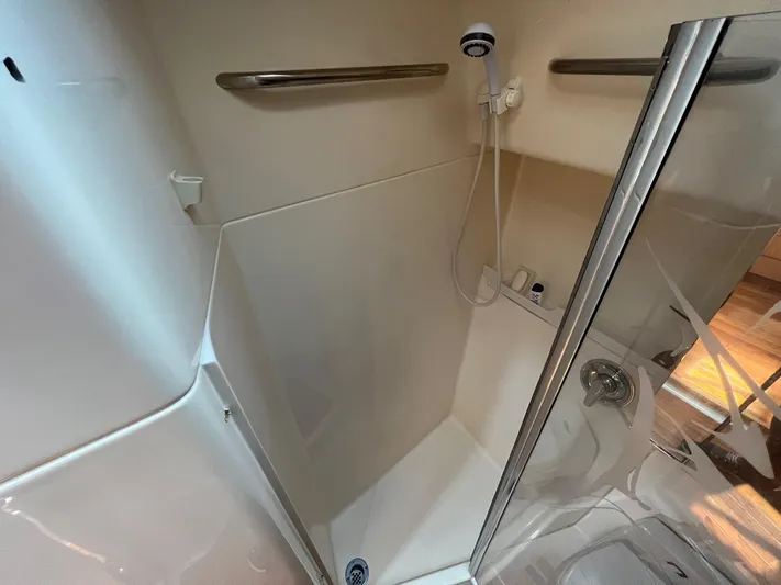 Chaos Yacht Photos Pics Shower area in 1996 Tiara Yachts 4300 Open, featuring glass door and handheld showerhead.