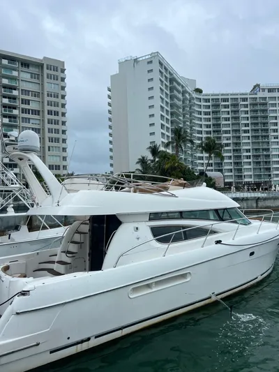  Yacht Photos Pics 2003 Jeanneau Prestige 46 yacht docked near modern high-rise buildings.