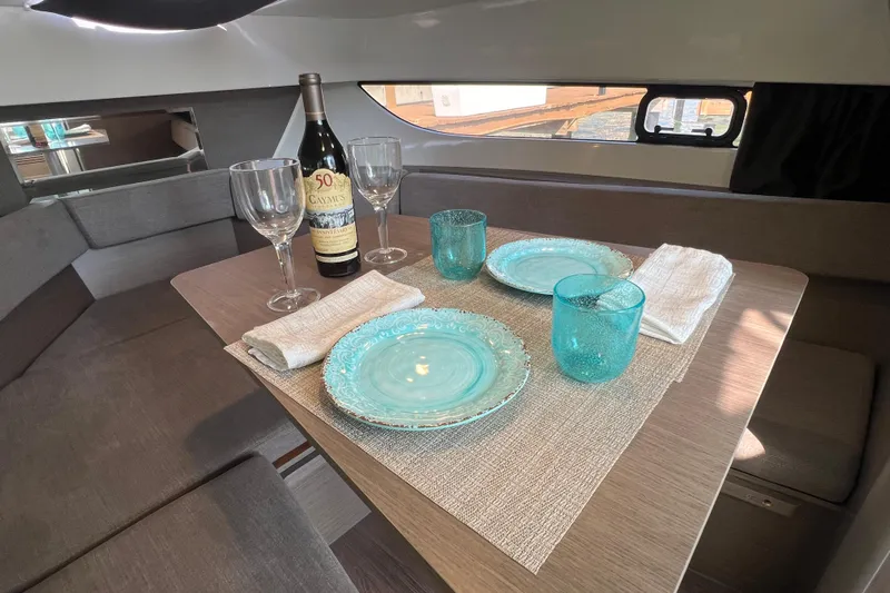  Yacht Photos Pics 2024 Beneteau Flyer 9 SUNdeck interior dining setup with elegant tableware and wine.