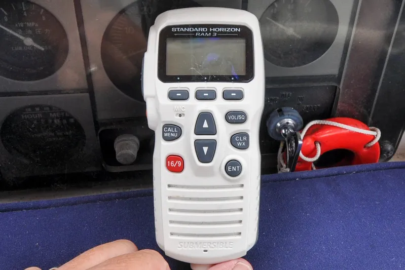Jezebel Yacht Photos Pics Hand holding Standard Horizon RAM3 marine radio on Sabre 426, 2004 model dashboard.