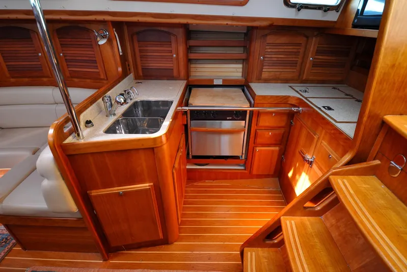 Jezebel Yacht Photos Pics 2004 Sabre 426 yacht interior kitchen with wooden cabinetry and stainless steel sink.