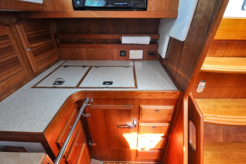 Jezebel Yacht Photos Pics 2004 Sabre 426 yacht interior with wooden cabinetry and countertop in the galley area.