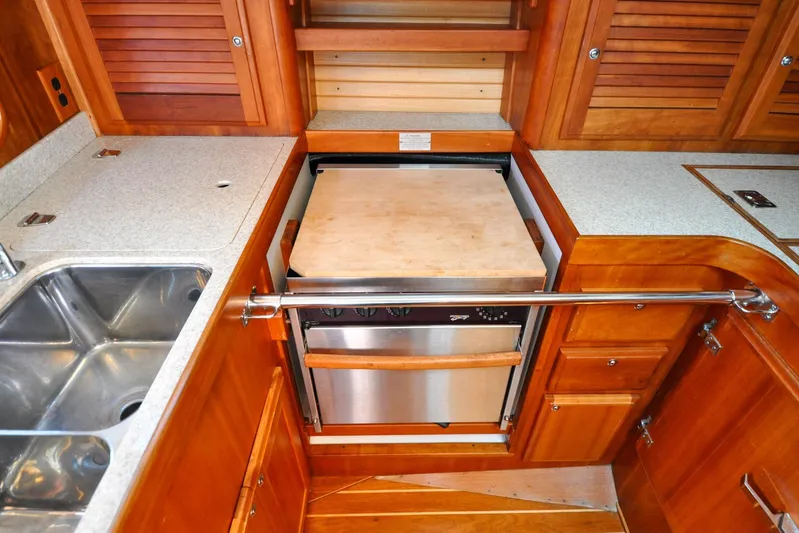 Jezebel Yacht Photos Pics 2004 Sabre 426 yacht kitchen with wooden cabinetry, stainless steel sink, and built-in appliances.