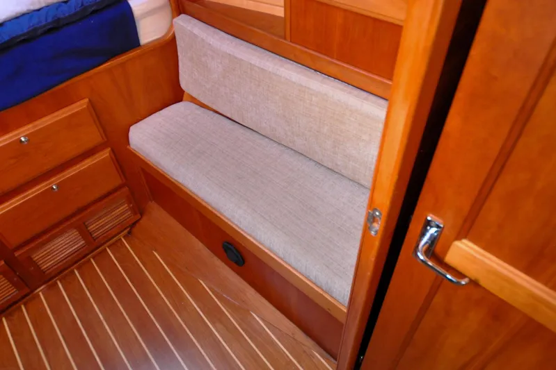 Jezebel Yacht Photos Pics Wooden interior of 2004 Sabre 426 yacht with cushioned seating and storage drawers.