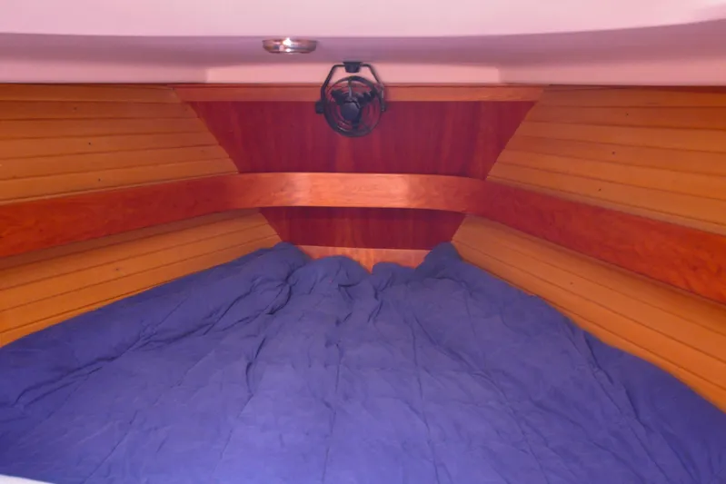 Jezebel Yacht Photos Pics Cozy cabin interior of 2004 Sabre 426 yacht with blue bedding and wooden paneling.